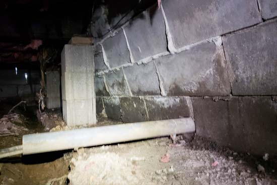 Image of severely bowed crawl space wall caused by foundation setttlement